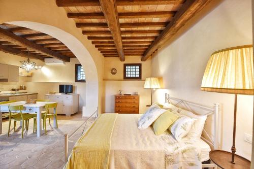 um quarto com uma cama, uma mesa e uma cozinha em Il Molino em Porto Ercole
