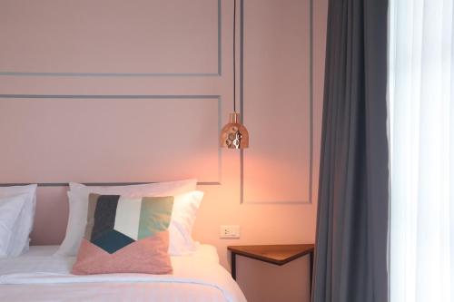a bedroom with a bed with two pillows at Goodnight Poshtel + Free Netflix in Hat Yai