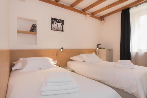 two beds sitting next to each other in a room at Rooms Kala in Šibenik