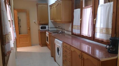 a kitchen with a sink and a washing machine at Apartamento Casa Go in Torla