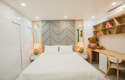 a bedroom with a bed and a desk and a teddy bear at Kim Phu Villa Hoi An in Hoi An