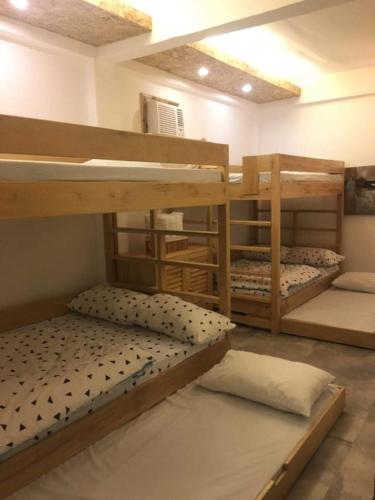 a room with three bunk beds in a room at Damara Beachfront Resort in Baler