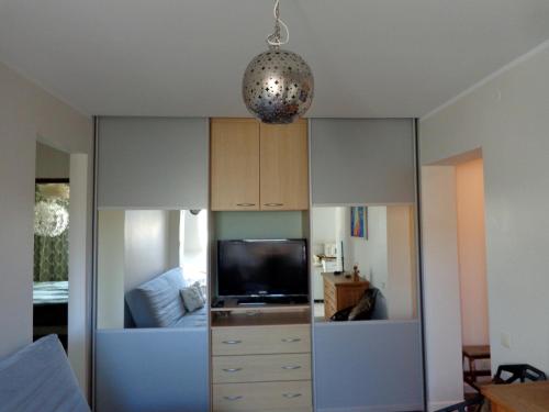 a living room with a large cabinet with a tv at Apartamentai Dorė in Nida
