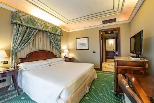 a hotel room with a bed and a television at River Chateau Hotel in Rome