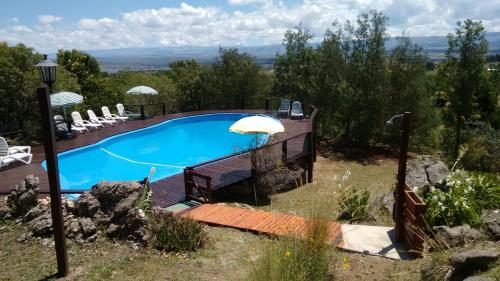 a swimming pool with an umbrella in a yard at Vista del Condor in Villa Ciudad de America