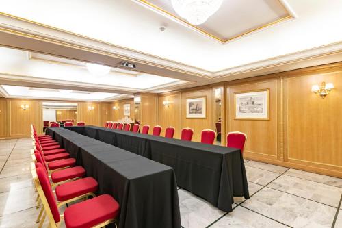 a conference room with a long table and red chairs at River Chateau Hotel in Rome