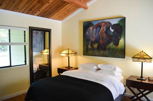 a bedroom with a bed with a picture of a bison at Indian Creek Inn in Philo