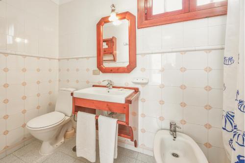 a bathroom with a toilet a sink and a mirror at Parque Santiago IV in Playa de las Americas