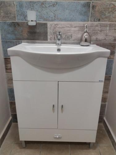 a white sink in a bathroom with a brick wall at Ellie's in Kardamaina