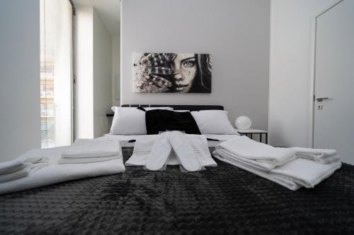a white bedroom with a large bed with white sheets at White Rooms in Reggio Calabria