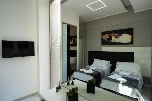 a bedroom with a bed and a mirror at White Rooms in Reggio Calabria