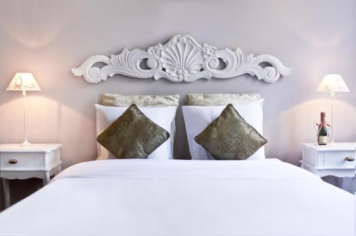 una camera da letto con un letto bianco con due tavoli e due lampade di B&B X2Brussels a Bruxelles