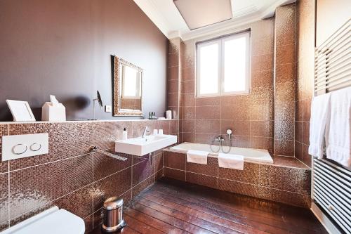 La salle de bains est pourvue d'une baignoire, d'un lavabo et d'un miroir. dans l'établissement B&B X2Brussels, à Bruxelles