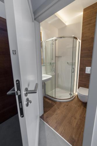 a bathroom with a glass shower and a toilet at Novopolska - Hotel i Restauracja in Kościan