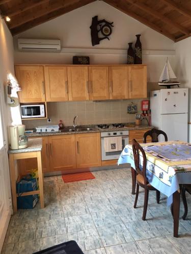 a kitchen with a table and a white refrigerator at Adelaide House in Praia do Norte
