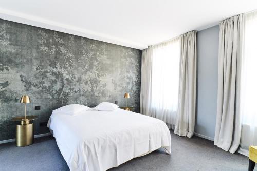a bedroom with a white bed and a gray wall at B&B X2Brussels in Brussels