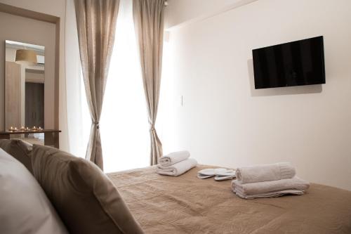 1 dormitorio con 1 cama con toallas en AT.thea ATHENS BOUTIQUE APARTMENTS en Athens