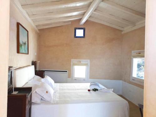 a bedroom with a white bed and two windows at Pascaraymondo Suite Palace in Gallipoli