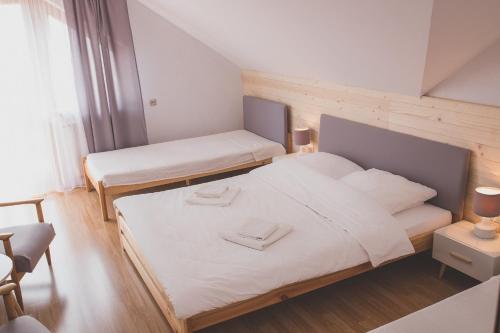 a small bedroom with two beds and a window at Pensjonat Zacisze in Czchów
