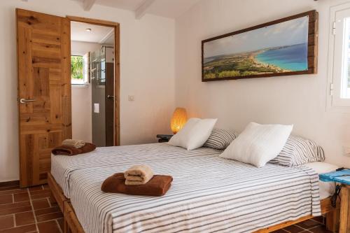 a bedroom with two beds and a picture on the wall at Casa Little China in Es Pujols