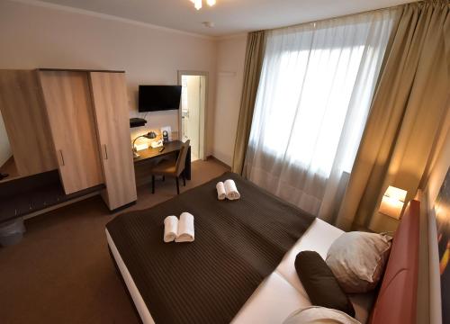a hotel room with a bed and a desk at Hotel Bürgerhof in Cologne