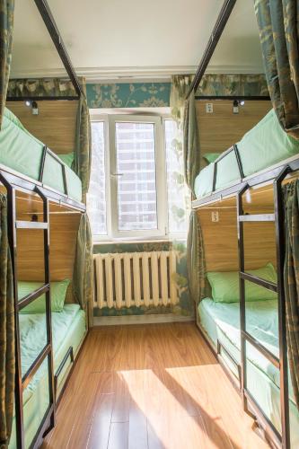 a room with three bunk beds and a window at City guesthouse & tours in Ulaanbaatar
