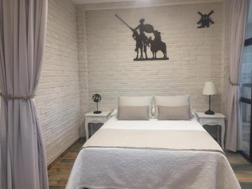 Un dormitorio con una cama y una pared. en Ático del Rojas, en Toledo