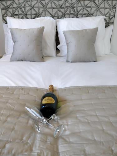 a bottle of wine sitting on top of a bed at Les Gîtes du Cap Cod in Varengeville-sur-Mer