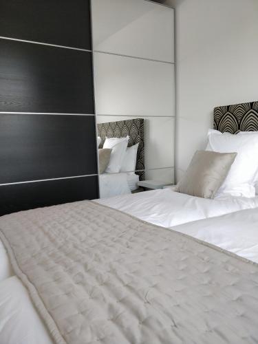a bedroom with two white beds and a mirror at Les Gîtes du Cap Cod in Varengeville-sur-Mer