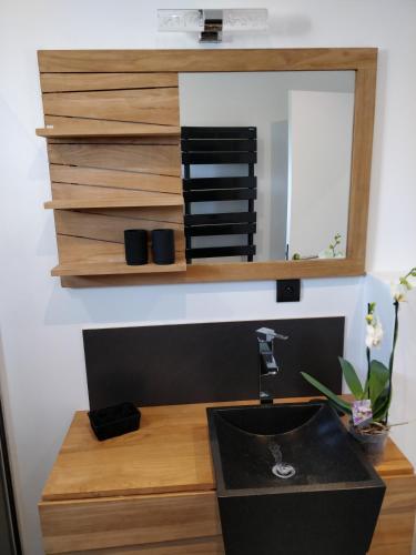 a bathroom with a sink and a mirror at Les Gîtes du Cap Cod in Varengeville-sur-Mer