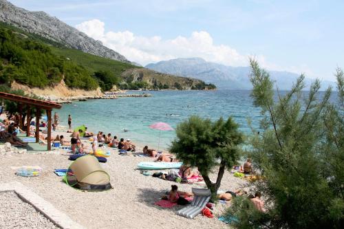 een groep mensen op een strand vlakbij het water bij Apartmani Blazevic in Omiš