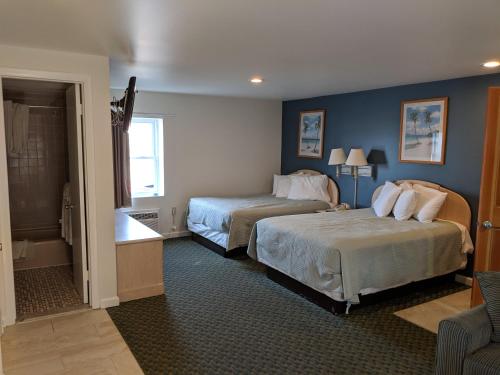 a hotel room with two beds and a bathroom at Crystal Sands Motel in Ocean City