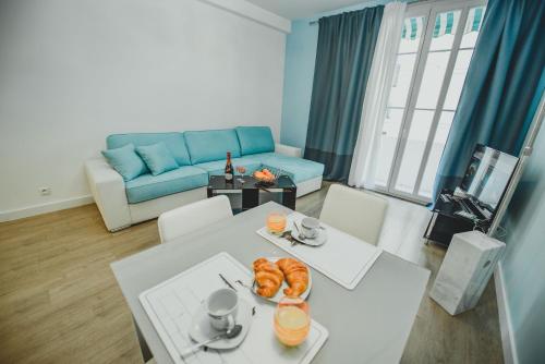 - un salon avec une table blanche et un canapé bleu dans l'établissement AzurAppart 3room Nice Promenade, à Nice