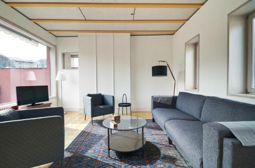 uma sala de estar com um sofá e uma mesa em Duplex de charme au cœur de la vieille ville de Sion em Sião