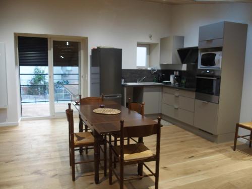 cocina con mesa de madera y comedor en Gît' de Pom', en Saint-Romain-de-Lerps