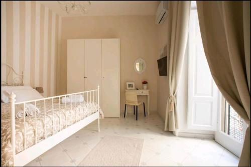 a white bedroom with a bed and a desk at Borgo Santa Lucia Apartment in Naples