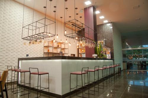 a bar in a restaurant with red stools at Arrey Gran Hotel in Teresina