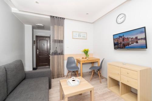 a living room with a couch and a table at Apartment Ogrody in Gdańsk