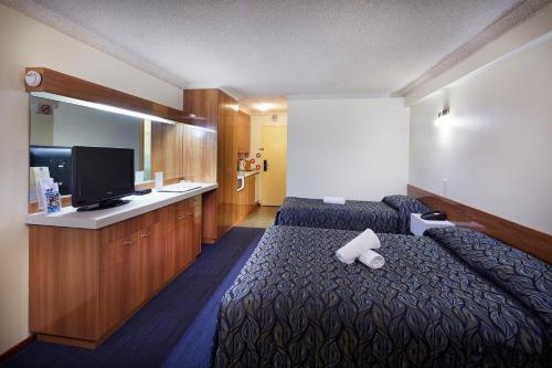 a hotel room with a bed and a flat screen tv at Windsor Lodge in Perth