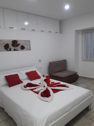 a bedroom with a white bed with red decorations on it at APARTMA SEA VIEW in Portorož