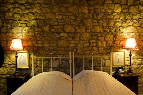 an open book in front of a stone wall with two lamps at Atrion Highland Hotel in Elatochori