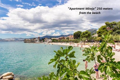 a view of a beach with people in the water at Apartment Seaside Mireja in Kaštela
