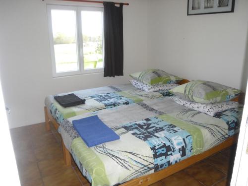 - un lit avec 2 oreillers et une couverture dans l'établissement La Petite Grange, à Lorignac