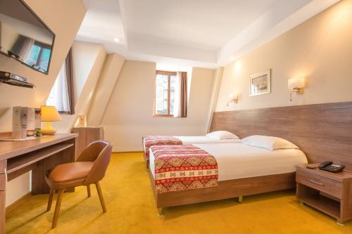 a bedroom with a bed and a desk and a chair at Urban Boutique Hotel in Tbilisi City