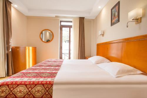a hotel room with a large bed and a window at Urban Boutique Hotel in Tbilisi City