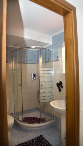 a bathroom with a shower with a toilet and a sink at Elephant House in Heraklio