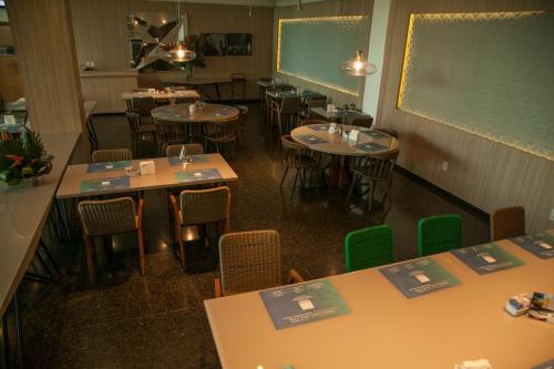 a classroom with tables and chairs and a chalkboard at Arrey Gran Hotel in Teresina