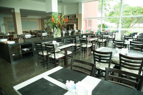 a dining room with tables and chairs and a cafeteria at Arrey Gran Hotel in Teresina
