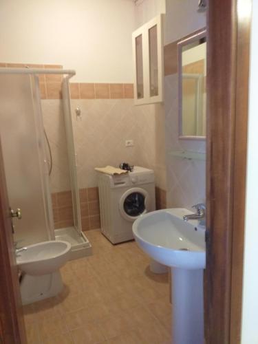 a bathroom with a toilet sink and a washing machine at Appartamento Marina in Marina di Carrara