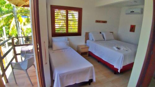 ein Schlafzimmer mit einem Bett und einem Balkon in der Unterkunft Corvina Suites in Praia do Forte